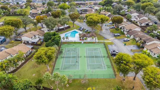 an aerial view of a residential houses with yard