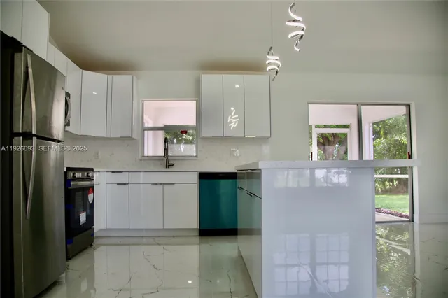 a kitchen with cabinets a window and stainless steel appliances