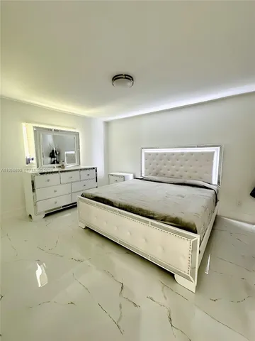 a spacious bedroom with a bed and a cabinets