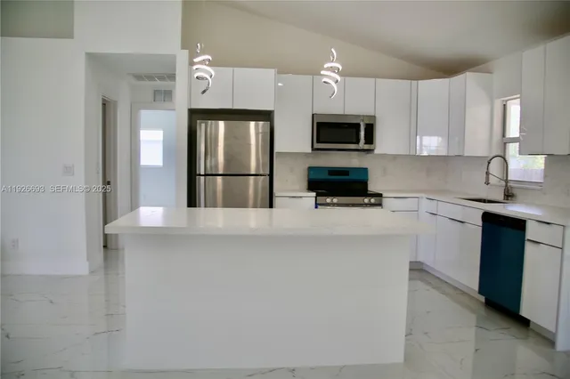 a kitchen with stainless steel appliances a refrigerator sink and microwave