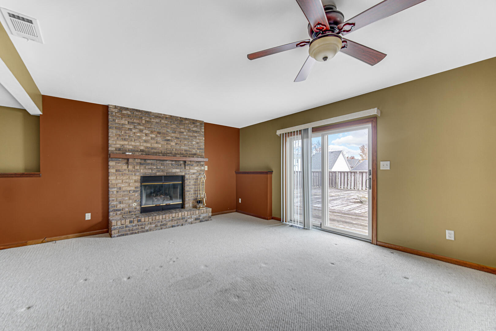 700 Meadow Lane Crown Point, IN 46307 - Photo 19 of 28 an empty room with windows fireplace and a ceiling fan