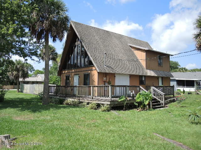 a view of backyard of house with green space
