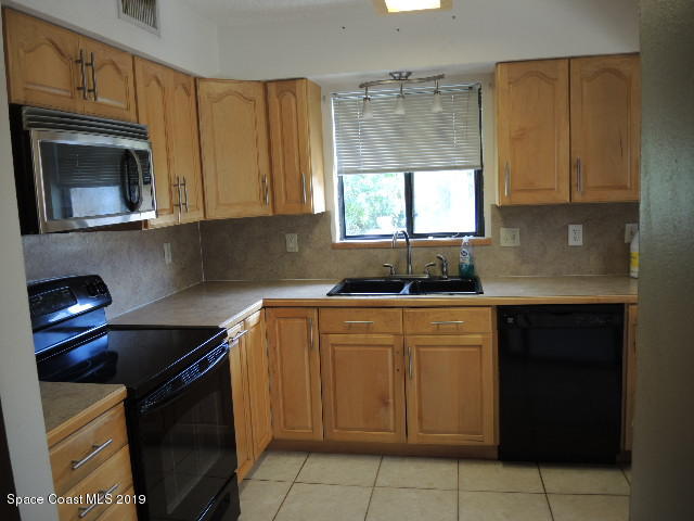 6990 Boston Road Cocoa, FL 32927 - Photo 11 of 26 a kitchen with a sink a stove and cabinets