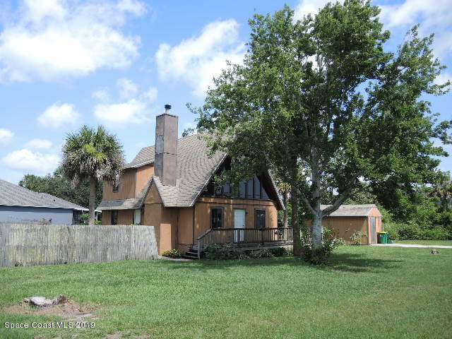 6990 Boston Road Cocoa, FL 32927 - Photo 3 of 26 a front view of a house with a garden and trees