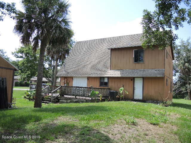 6990 Boston Road Cocoa, FL 32927 - Photo 7 of 26 a view of a house with a yard and a large tree