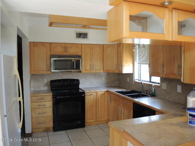 6990 Boston Road Cocoa, FL 32927 - Photo 10 of 26 a kitchen with a sink a counter top space and stainless steel appliances