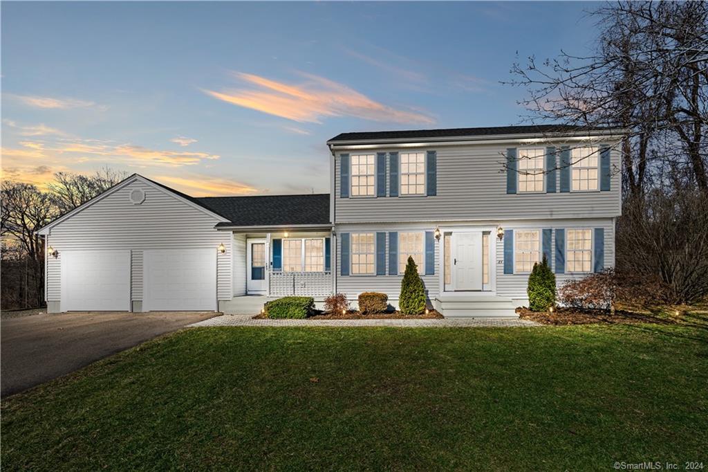 a front view of a house with a yard and trees