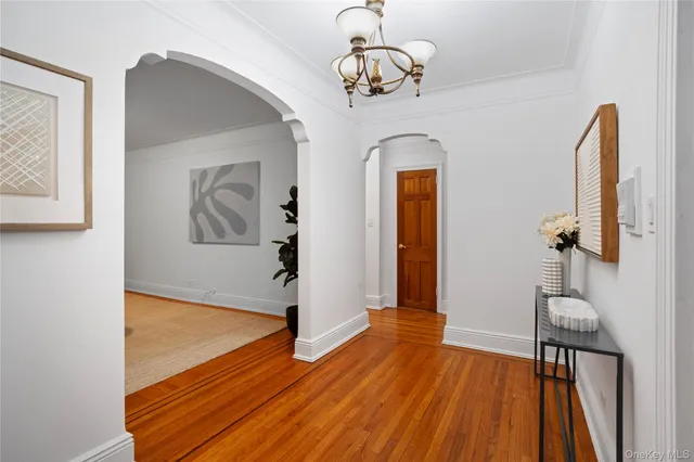 a view of a room with wooden floor staircase and a chandelier