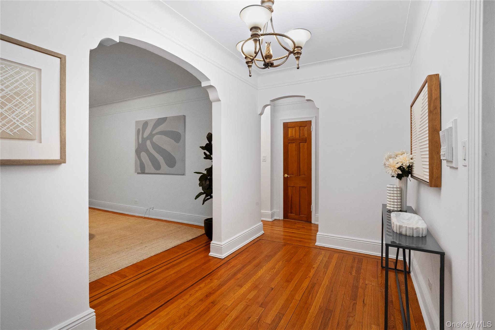 a view of a room with wooden floor staircase and a chandelier