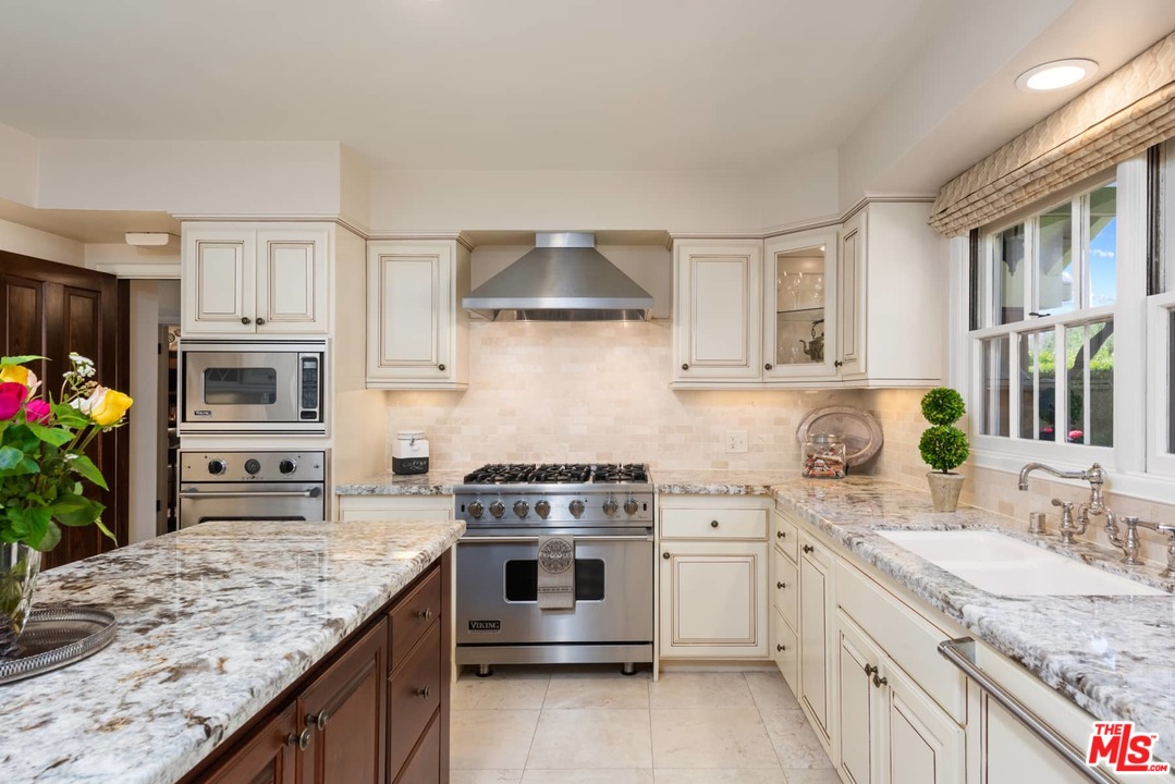 1020 Casiano Road Los Angeles, CA 90049 - Photo 8 of 31 a kitchen with granite countertop a sink stove and cabinets