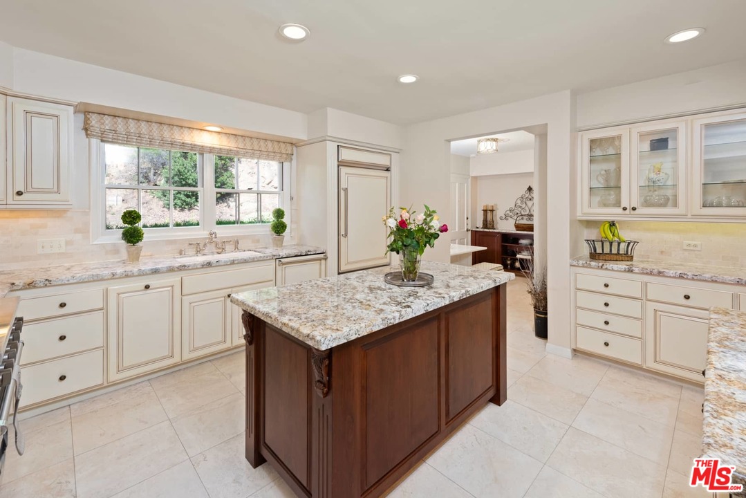 1020 Casiano Road Los Angeles, CA 90049 - Photo 9 of 31 a kitchen with granite countertop a sink window and cabinets