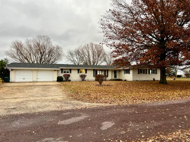 a front view of a house with a yard and trees