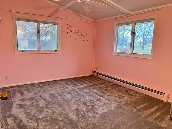 a view of a small space with wooden floor and a window