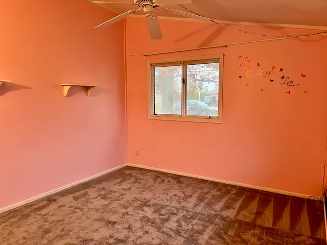an empty room with closet and a chandelier fan