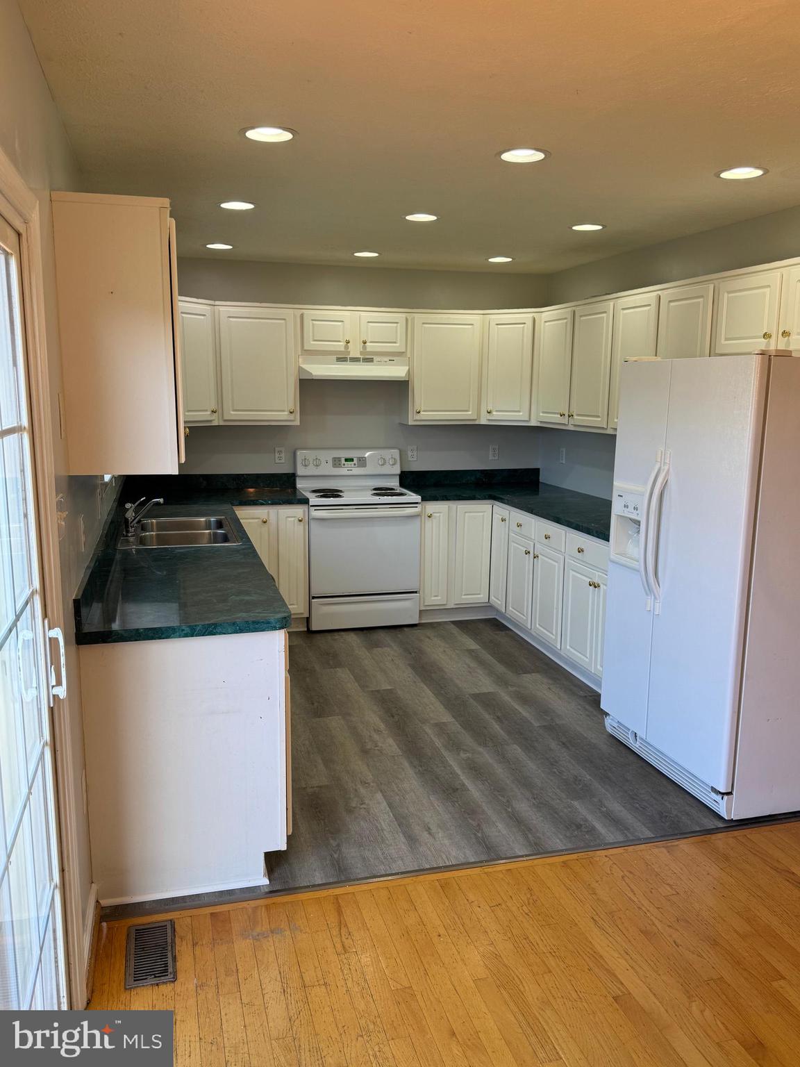 34 Stuart Court Strasburg, VA 22657 - Photo 18 of 54 a kitchen with granite countertop a refrigerator a sink and white cabinets