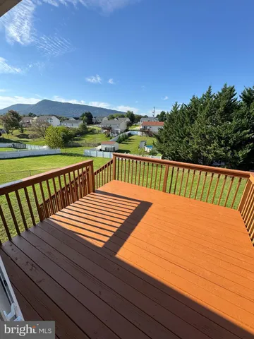 a view of a balcony with wooden floor and fence