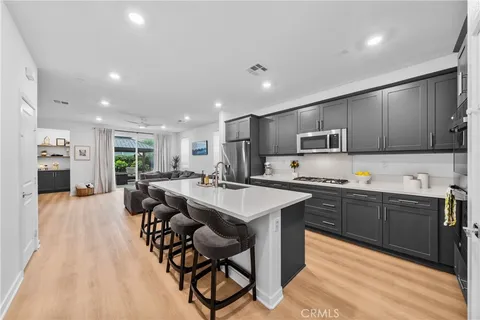 a large kitchen with stainless steel appliances lots of counter top space and furniture