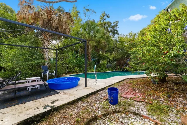 an aerial view of residential houses with outdoor space and trees