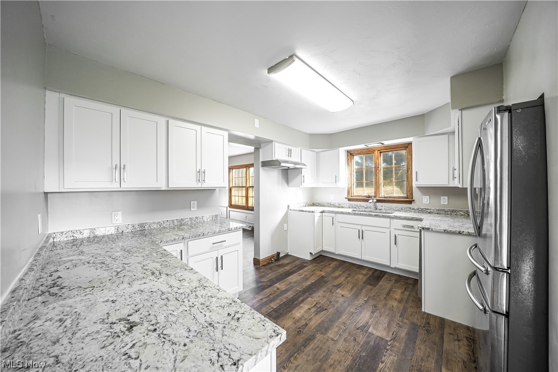 10258 Gilbert Road Newton Falls, OH 44444 - Photo 6 of 37 Kitchen with white cabinetry, dark hardwood / wood-style flooring, light stone counters, and stainless steel fridge