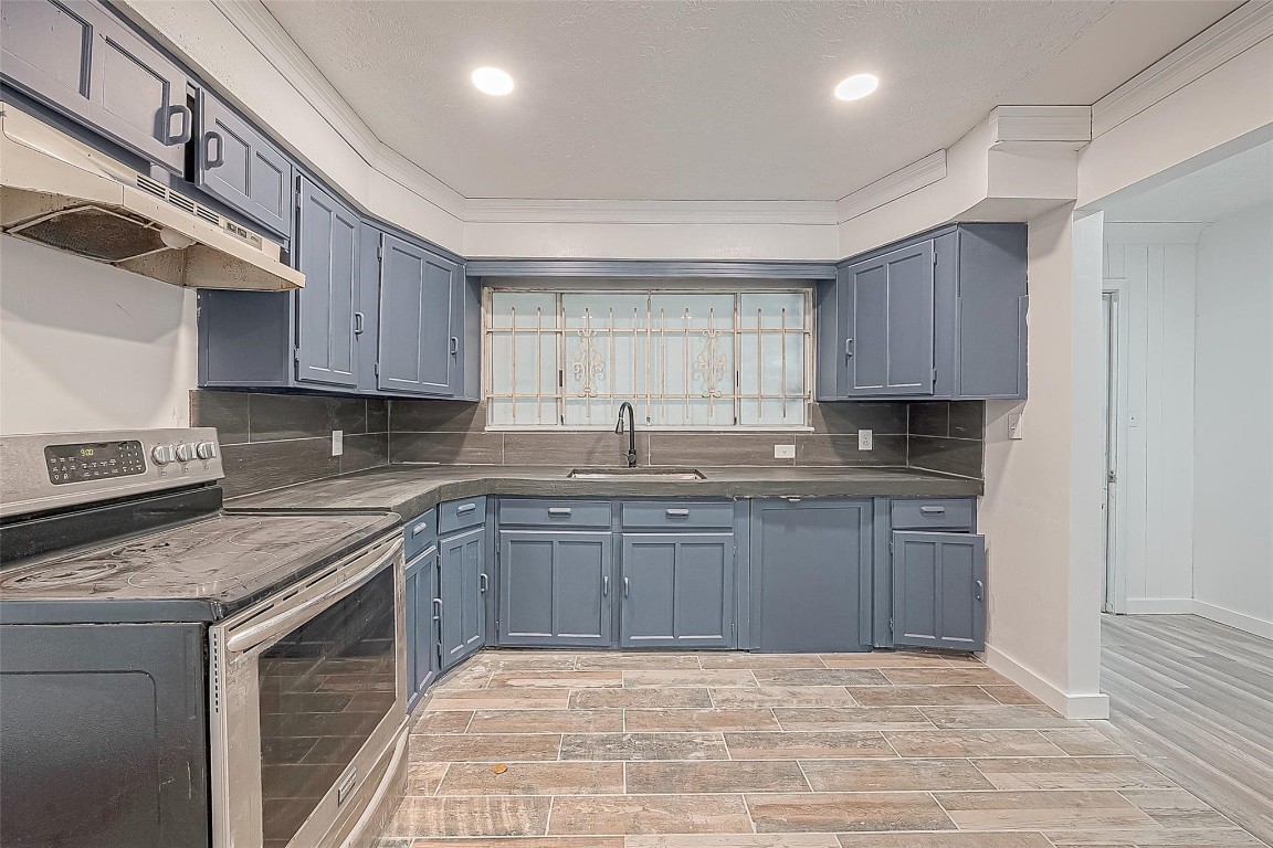 6718 Madrid Street Houston, TX 77021 - Photo 11 of 26 a kitchen with granite countertop a sink stainless steel appliances and cabinets