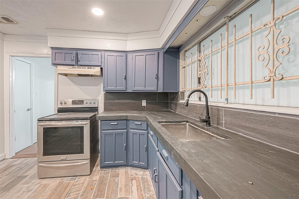 6718 Madrid Street Houston, TX 77021 - Photo 12 of 26 a kitchen with granite countertop a sink and a stove top oven