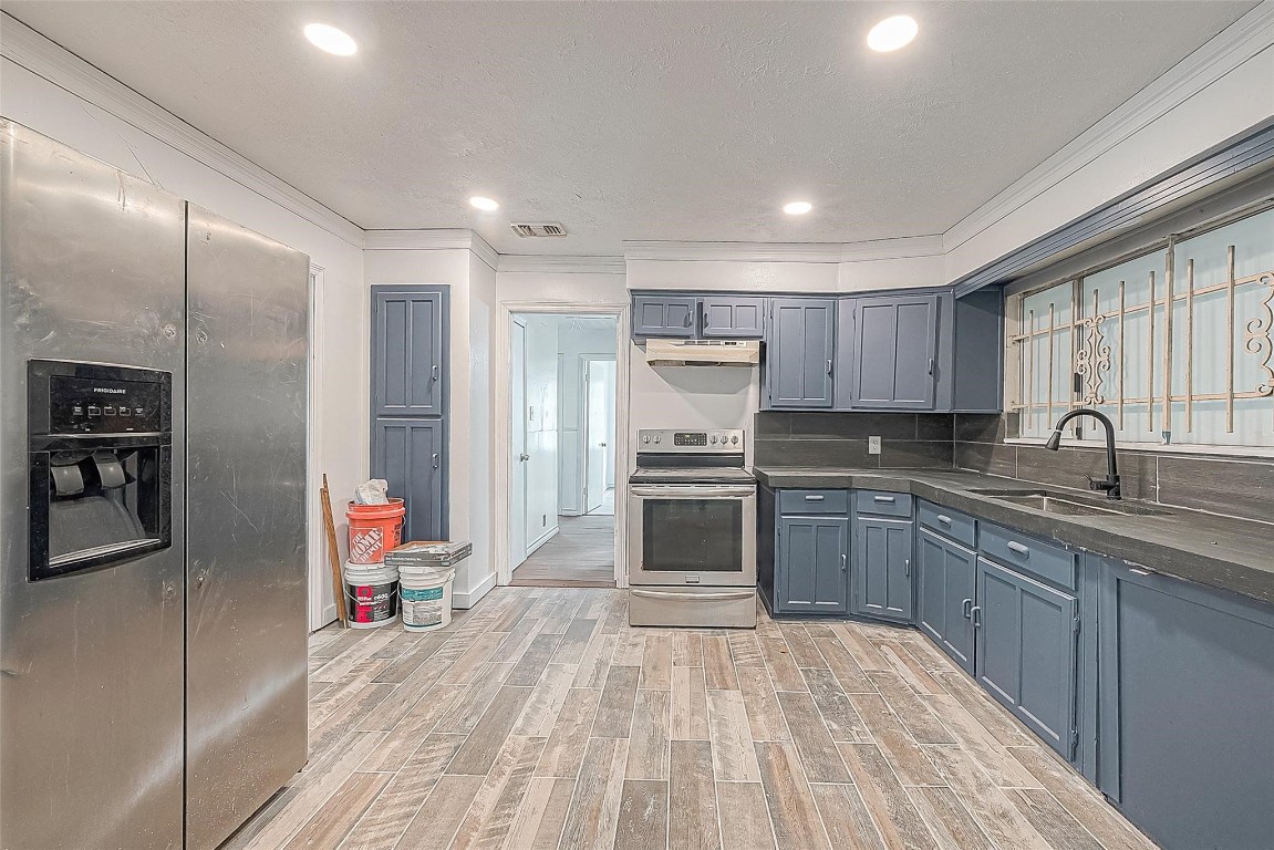 6718 Madrid Street Houston, TX 77021 - Photo 15 of 26 a kitchen with kitchen island granite countertop a sink cabinets and stainless steel appliances