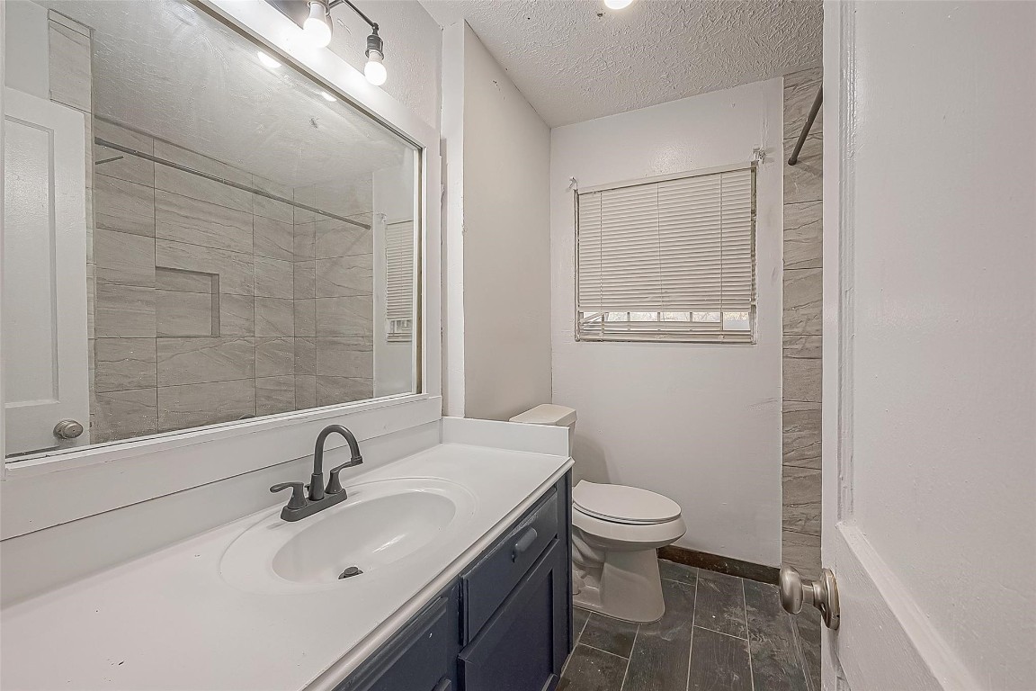 6718 Madrid Street Houston, TX 77021 - Photo 24 of 26 a bathroom with a sink a toilet and a mirror