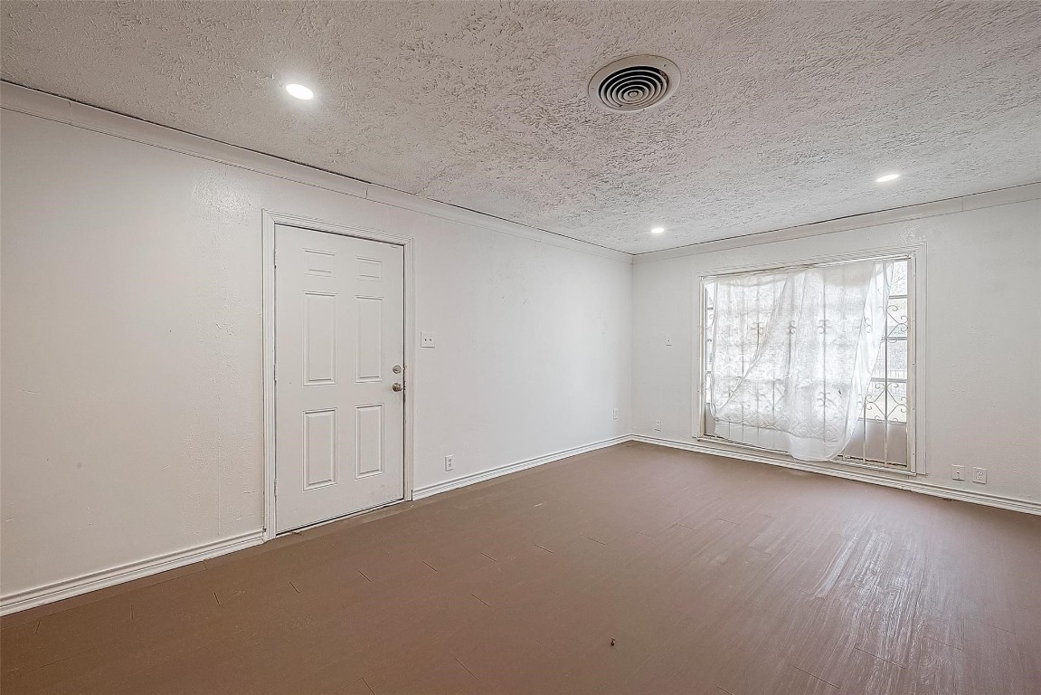 6718 Madrid Street Houston, TX 77021 - Photo 6 of 26 an empty room with wooden floor and windows