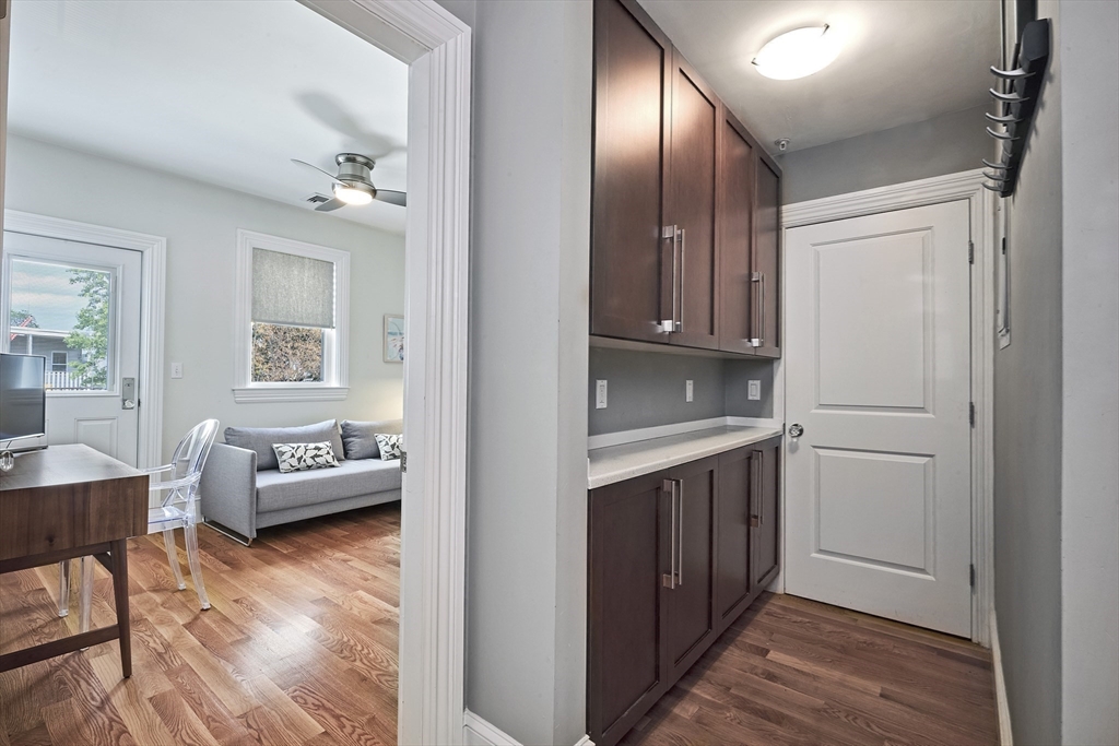 870 East 4th Street, Unit 2 Boston, MA 02127 - Photo 11 of 20 a view of a kitchen from the hallway with couches and wooden floor