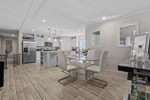 a living room with stainless steel appliances kitchen island granite countertop furniture wooden floor and a view of kitchen