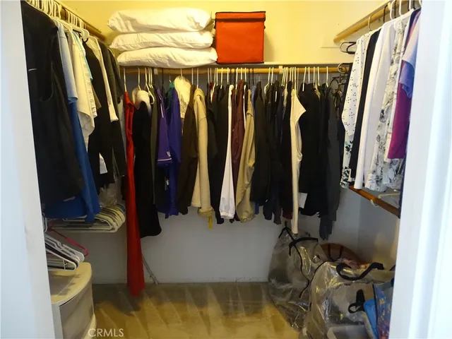 a view of walk in closet with clothes and shoes