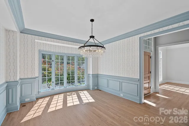 a bedroom with a balcony a bed and a large window with potted plants