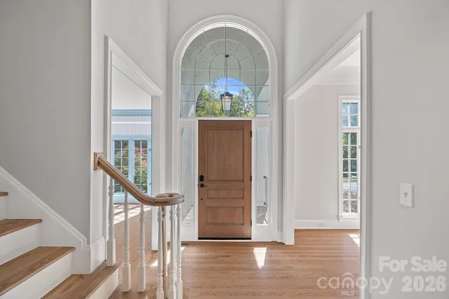 a view of a hallway with entryway wooden floor and front door