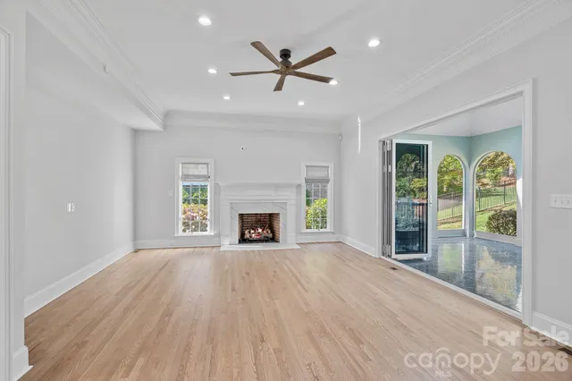 a view of an empty room with a fireplace and a window