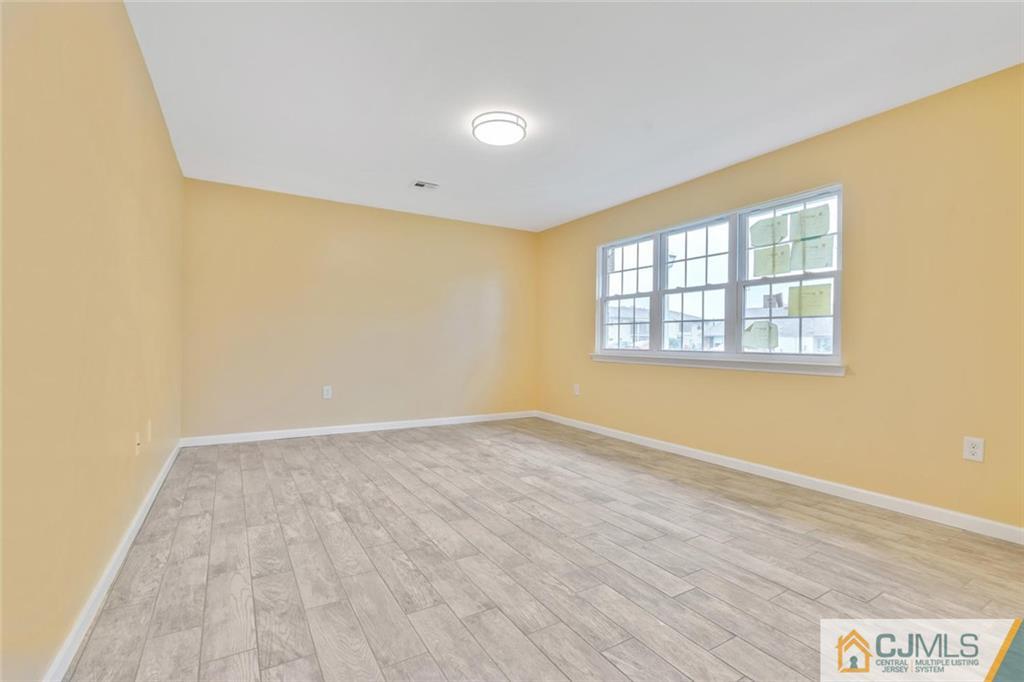 3 Valery Road Old Bridge, NJ 07747 - Photo 6 of 19 an empty room with wooden floor and windows