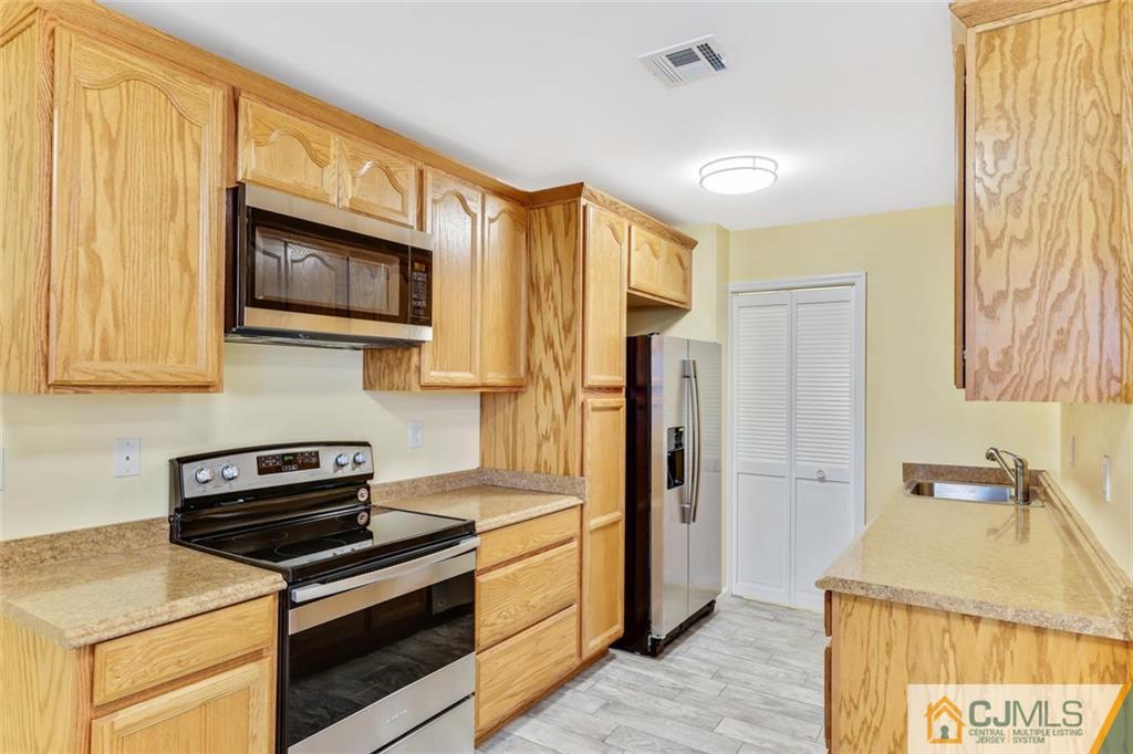 3 Valery Road Old Bridge, NJ 07747 - Photo 10 of 19 a kitchen with stainless steel appliances a stove microwave and refrigerator