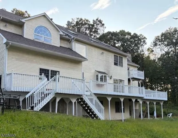 a view of a house with a yard and deck