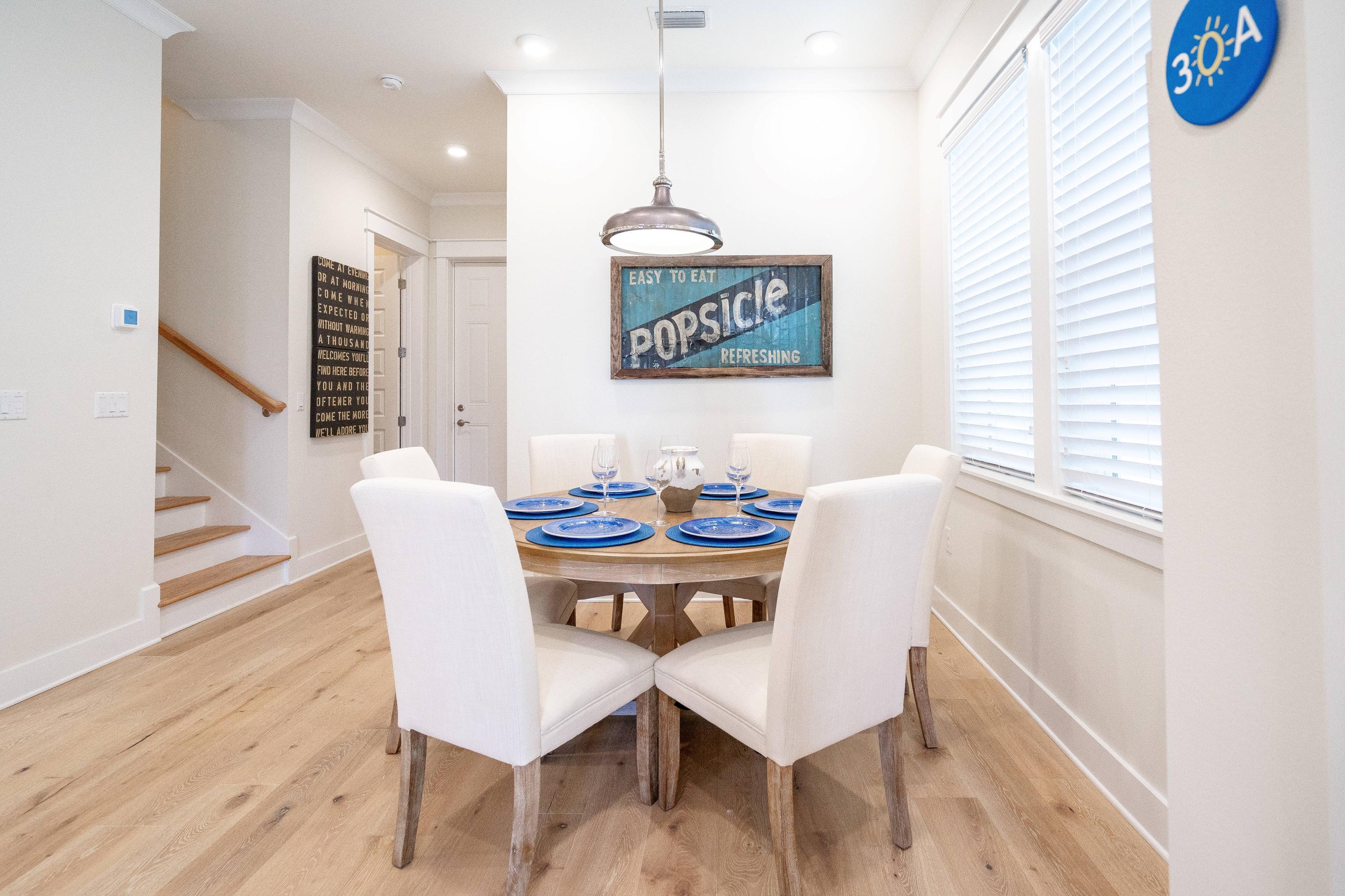 89 East Pine Lands Loop, Unit A Inlet Beach, FL 32461 - Photo 4 of 41 a view of a dining room with furniture wooden floor and a chandelier