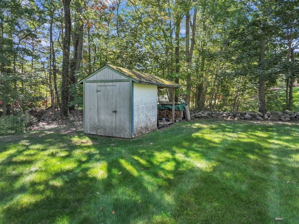 35 Laurelwood Road Rutland, MA 01543 - Photo 35 of 37 a backyard of a house with lawn chairs and wooden fence