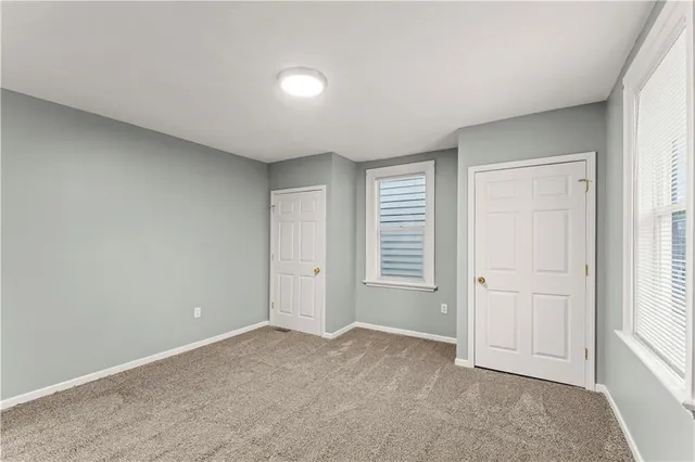 an empty room with windows and closet