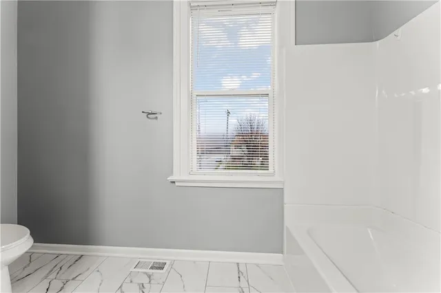 a view of a town with barn house and large tree