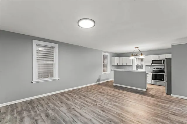 a kitchen with stainless steel appliances granite countertop a refrigerator a stove a sink and white cabinets