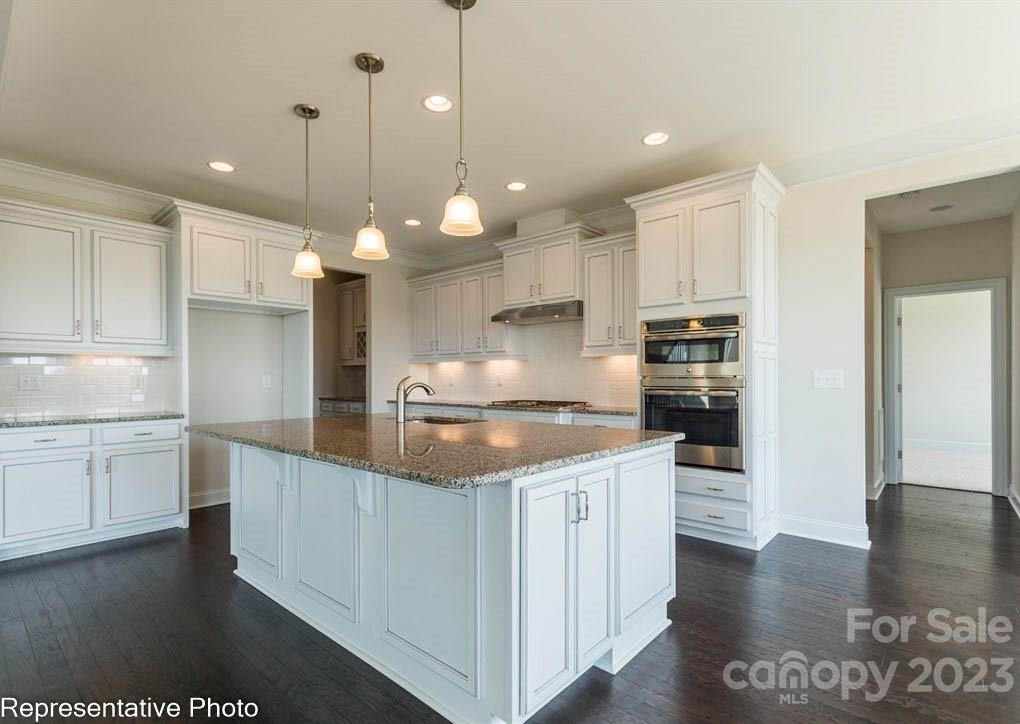 16327 Loch Raven Road Huntersville, NC 28078 - Photo 11 of 42 a kitchen with kitchen island granite countertop a stove a sink a refrigerator and white cabinets with wooden floor