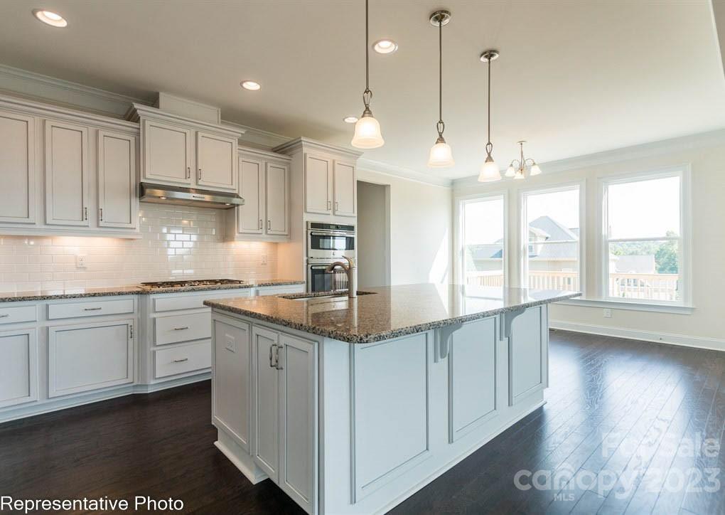 16327 Loch Raven Road Huntersville, NC 28078 - Photo 10 of 42 a kitchen with kitchen island granite countertop a stove a sink a center island a refrigerator and a wooden floor