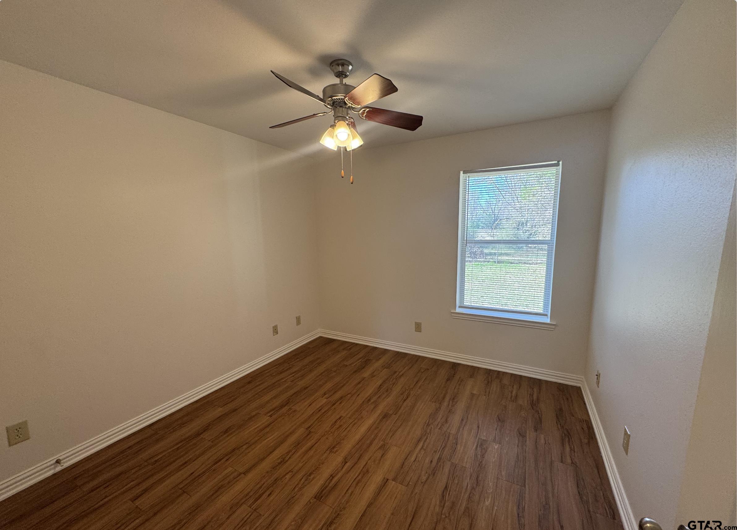 303 Kenneth Street Chandler, TX 75758 - Photo 22 of 33 a view of empty room with wooden floor and fan