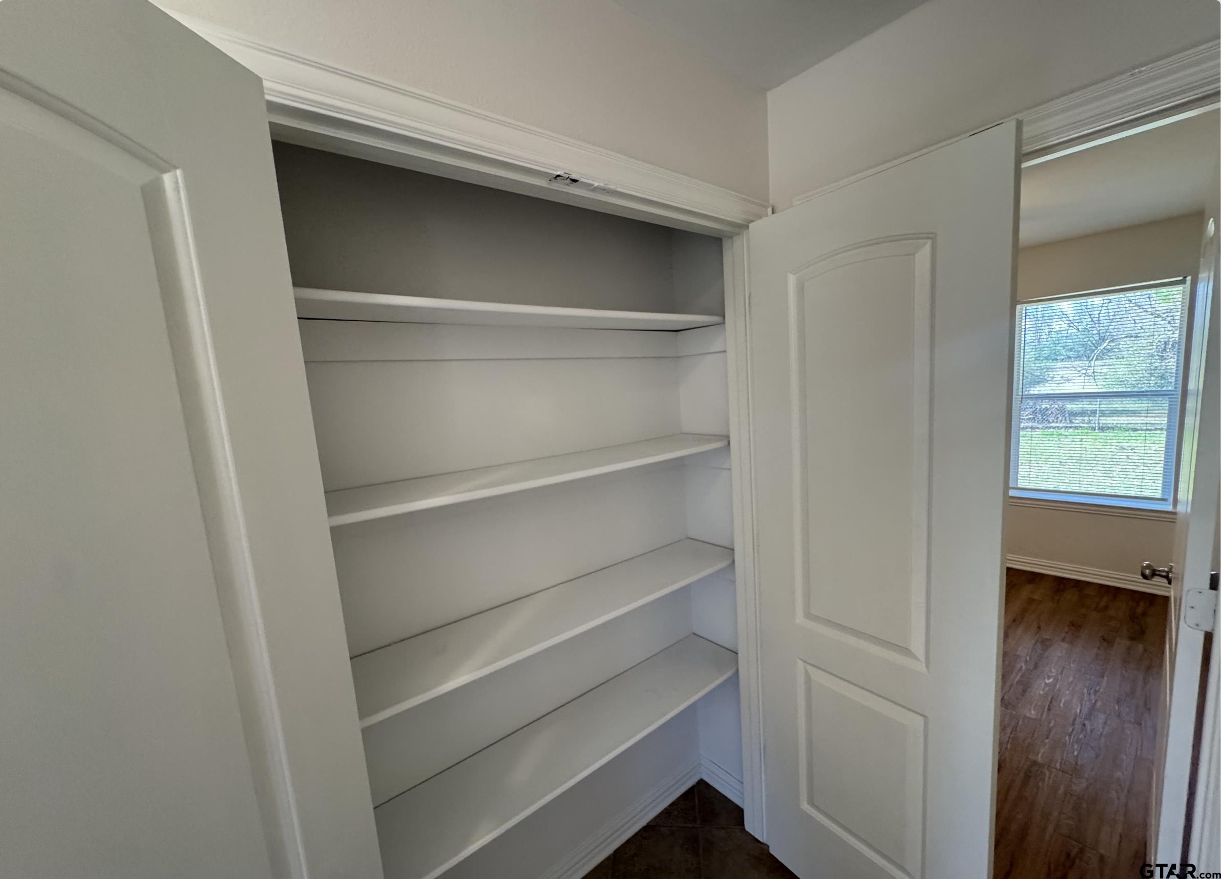303 Kenneth Street Chandler, TX 75758 - Photo 28 of 33 a view of walk in closet with empty racks