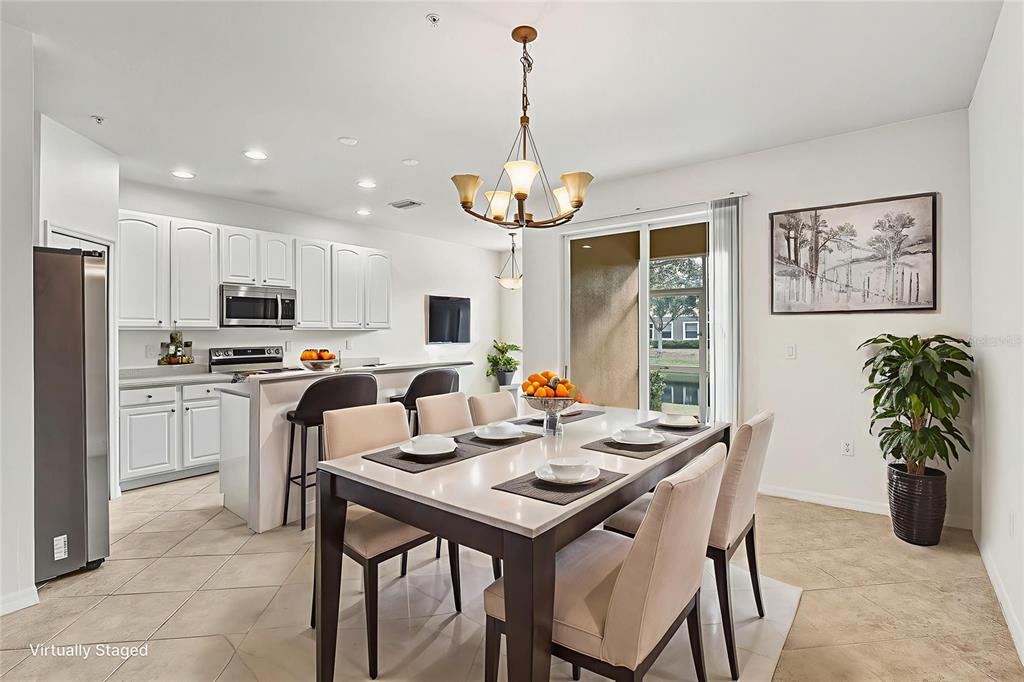 7928 Limestone Lane, Unit 19105 Sarasota, FL 34233 - Photo 11 of 37 a view of a dining room with furniture window and wooden floor