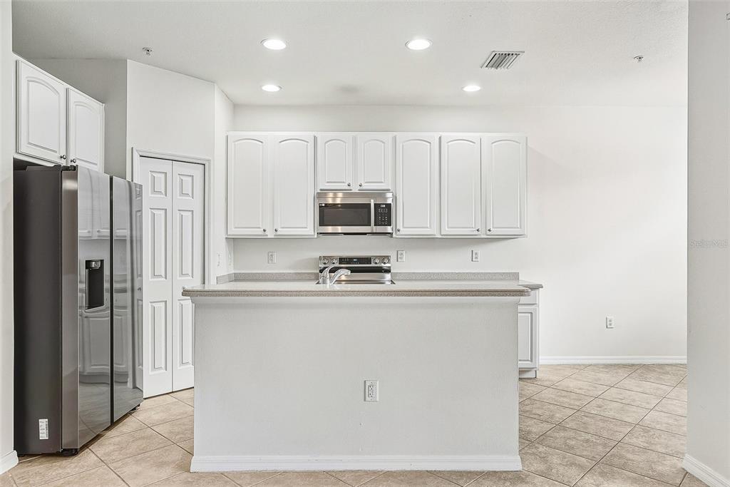 7928 Limestone Lane, Unit 19105 Sarasota, FL 34233 - Photo 13 of 37 a kitchen with stainless steel appliances granite countertop a refrigerator a stove a sink and a microwave