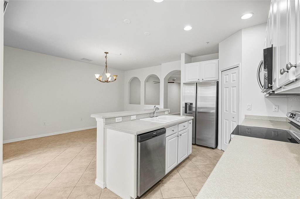 7928 Limestone Lane, Unit 19105 Sarasota, FL 34233 - Photo 16 of 37 a kitchen with stainless steel appliances granite countertop a sink a stove and a refrigerator