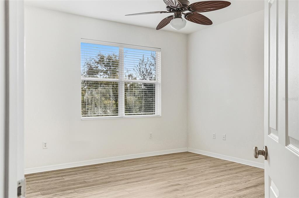7928 Limestone Lane, Unit 19105 Sarasota, FL 34233 - Photo 25 of 37 a view of an empty room with wooden floor and a window